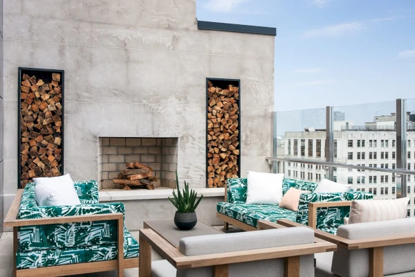 A rooftop seating area with a fireplace and city view.