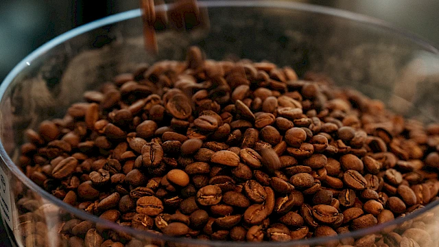 Coffee beans pouring into a container.