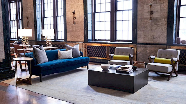 A stylish living room with a sofa, armchairs, lamps, and a coffee table.